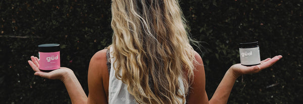 Lady from behind, holding two Güd Things products